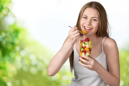 pessoa comendo fruta que ajuda no colesterol alto