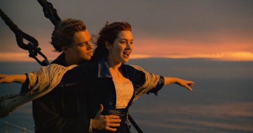 Cena icônica de Titanic, com Jack e Rose na proa do navio: uma história de amor, sacrifício e um marco na história do cinema.